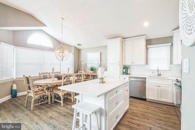 kitchen with appliances with stainless steel finishes, hardwood / wood-style flooring, white cabinetry, and sink