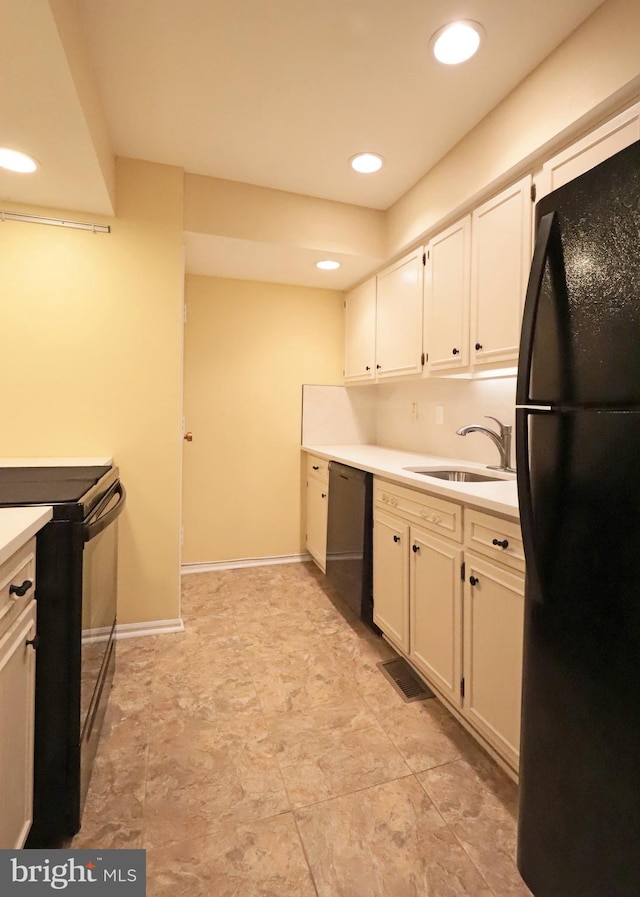 kitchen featuring sink, white cabinets, and black appliances