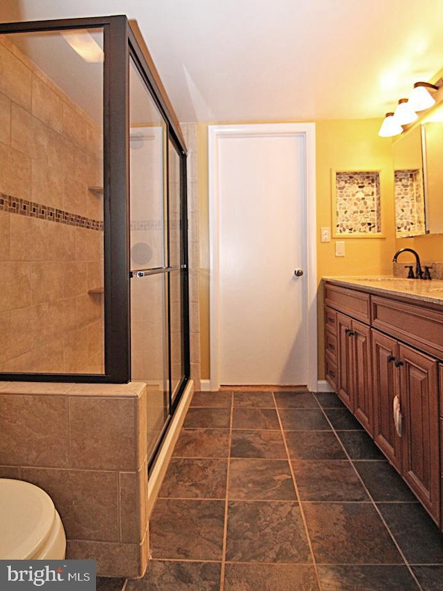 bathroom with vanity, toilet, and walk in shower