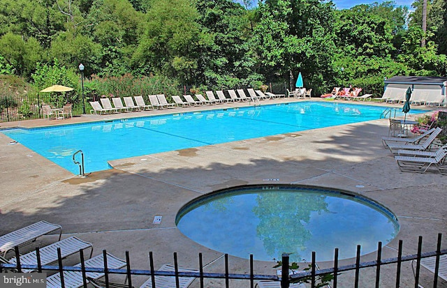 view of swimming pool with a hot tub and a patio area