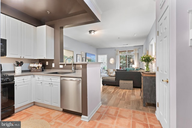 kitchen featuring light tile patterned flooring, sink, white cabinetry, kitchen peninsula, and black appliances