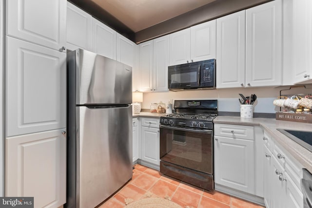 kitchen with white cabinetry, black appliances, and light tile patterned flooring