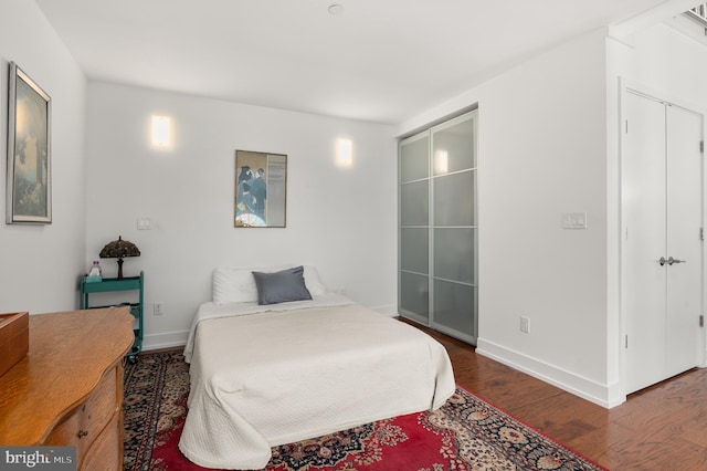 bedroom with dark hardwood / wood-style flooring