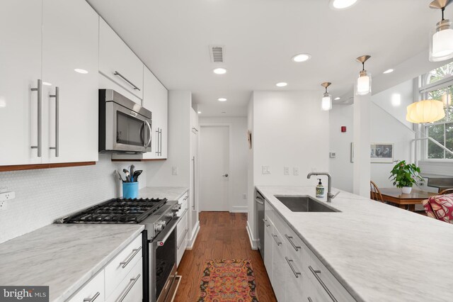 kitchen with stainless steel appliances, sink, pendant lighting, and white cabinets