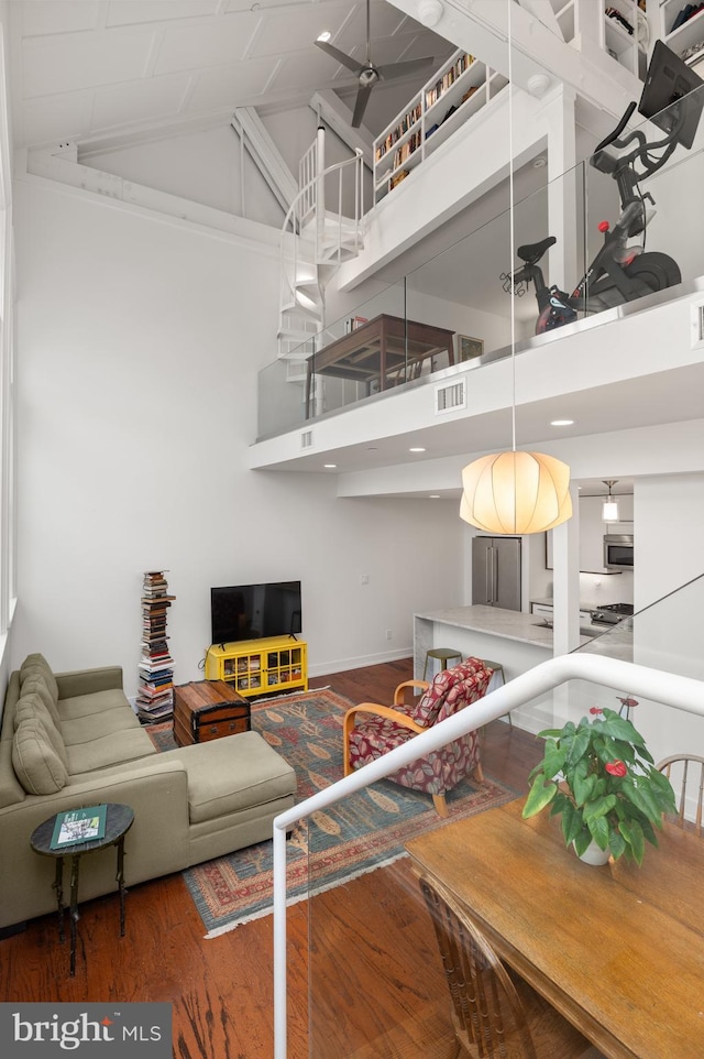 living room featuring dark hardwood / wood-style flooring, ceiling fan, and high vaulted ceiling