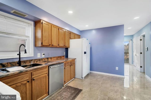 kitchen with sink, stainless steel dishwasher, and white refrigerator with ice dispenser