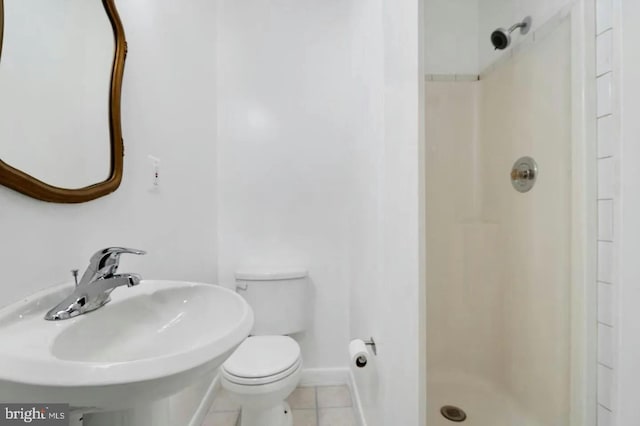 bathroom featuring tile patterned floors, toilet, walk in shower, and sink