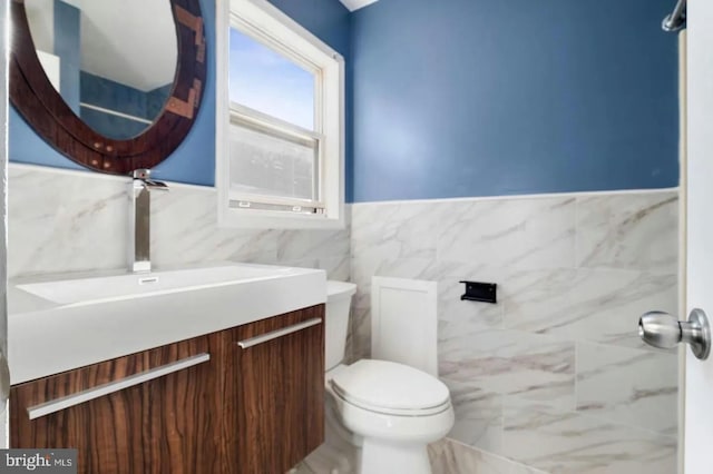 2396 Elvans Rd SE, Washington, DC 20020 - bathroom with tile walls, vanity, toilet, and wainscoting