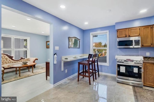 2396 Elvans Rd SE, Washington, DC 20020 - kitchen with stainless steel appliances, brown cabinetry, baseboards, and recessed lighting