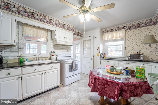 kitchen with white cabinetry, white electric range, sink, and a wealth of natural light