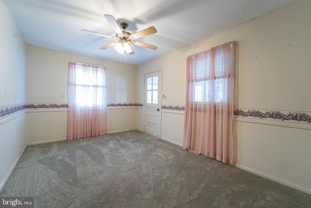 carpeted spare room featuring ceiling fan