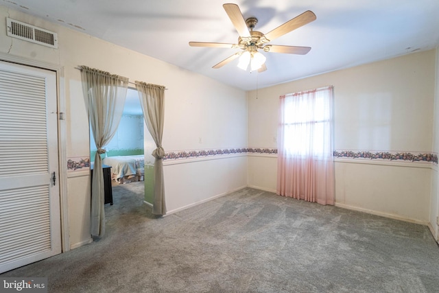 carpeted spare room with ceiling fan