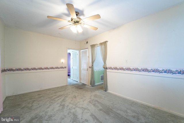 carpeted empty room featuring ceiling fan