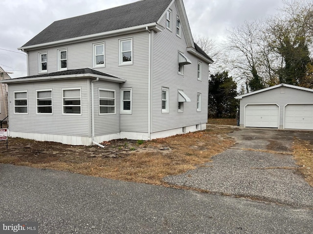 view of property exterior featuring a garage and an outdoor structure