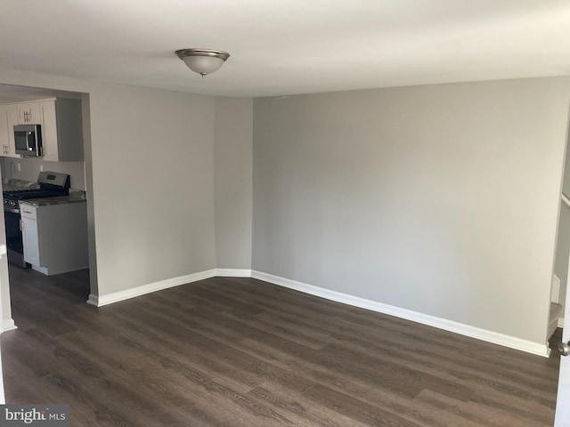 unfurnished room with dark hardwood / wood-style floors