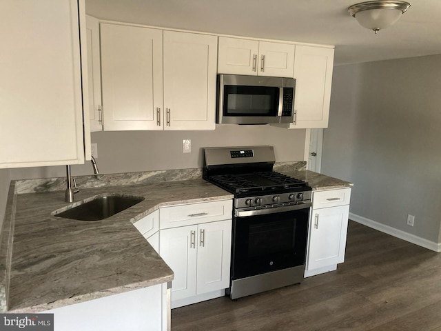 kitchen with sink, white cabinets, dark hardwood / wood-style floors, and appliances with stainless steel finishes