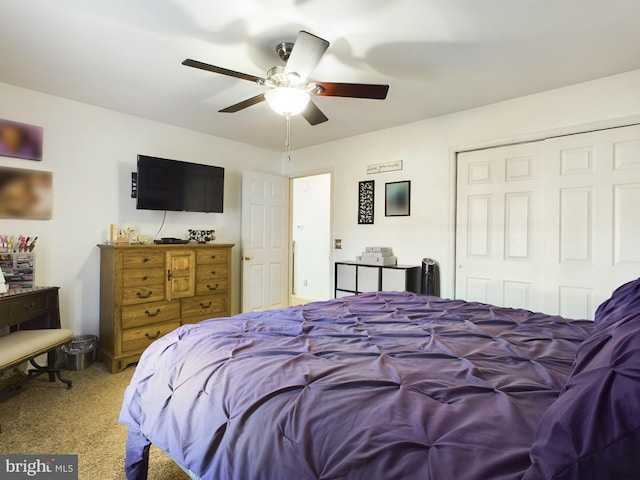 bedroom with ceiling fan, light carpet, and a closet