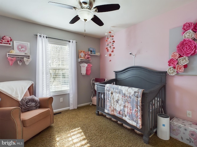 carpeted bedroom with ceiling fan and a nursery area