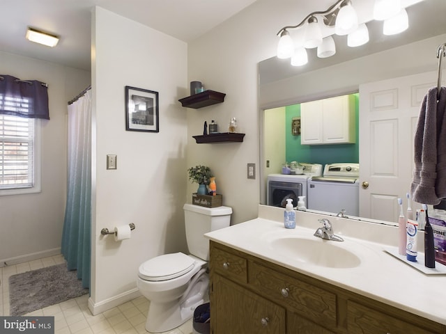 bathroom featuring washer and clothes dryer, vanity, toilet, and tile patterned flooring