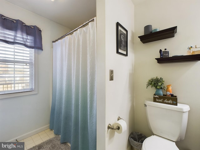 bathroom featuring a shower with shower curtain, tile patterned floors, and toilet