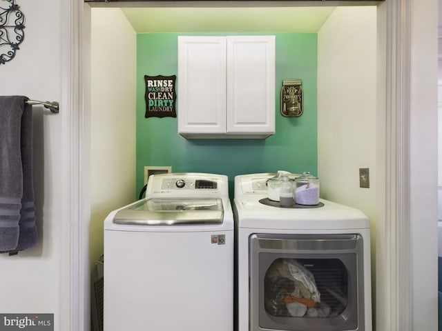 laundry area featuring washer and dryer and cabinets