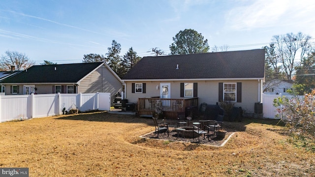 view of front facade featuring a front yard, a deck, and an outdoor fire pit