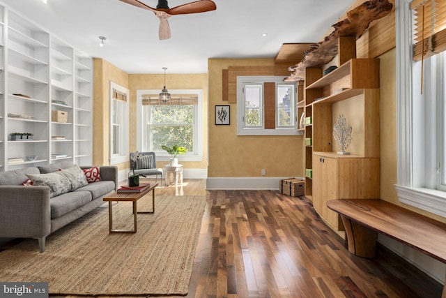 living area with ceiling fan and dark wood-type flooring