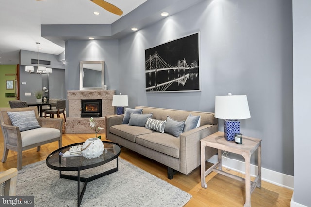 living room featuring a chandelier, hardwood / wood-style flooring, and a high end fireplace