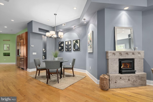 dining area with light hardwood / wood-style floors and a chandelier