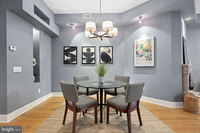 dining room featuring light hardwood / wood-style floors and an inviting chandelier