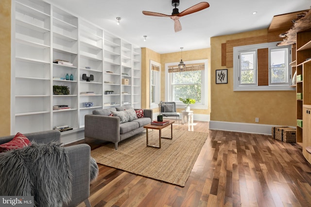 living room with dark hardwood / wood-style floors, built in features, and ceiling fan