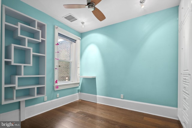 unfurnished room featuring ceiling fan and dark wood-type flooring