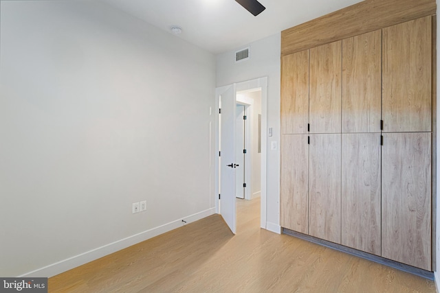 unfurnished bedroom with light hardwood / wood-style flooring, a closet, and ceiling fan