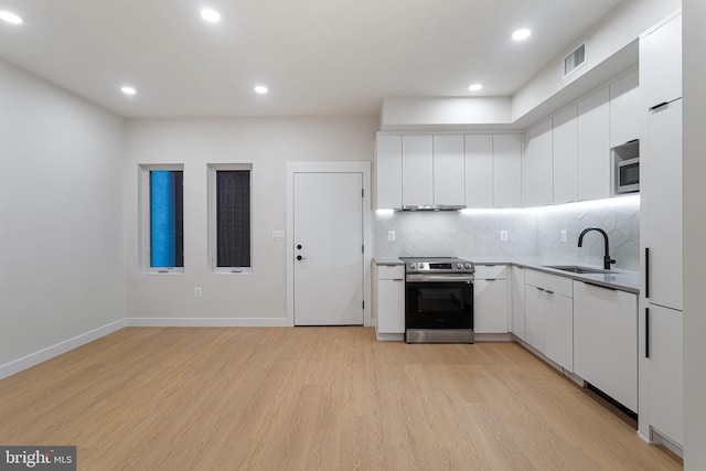 kitchen with light hardwood / wood-style floors, white cabinetry, stainless steel range with electric cooktop, and sink