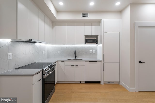 kitchen featuring light wood-type flooring, white cabinetry, sink, and appliances with stainless steel finishes