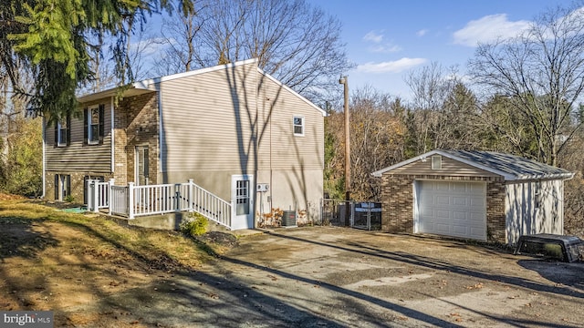 view of side of property featuring central AC unit, a garage, and an outbuilding