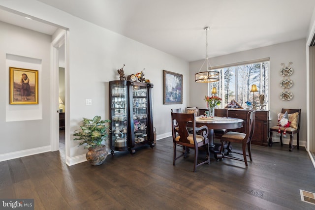 dining room with a chandelier and dark wood-type flooring