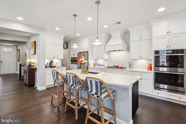 kitchen featuring appliances with stainless steel finishes, sink, dark hardwood / wood-style floors, and custom exhaust hood