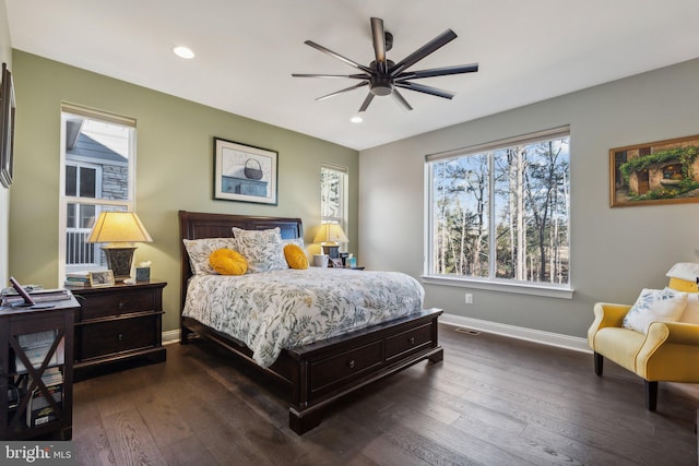 bedroom featuring ceiling fan, dark hardwood / wood-style floors, and multiple windows