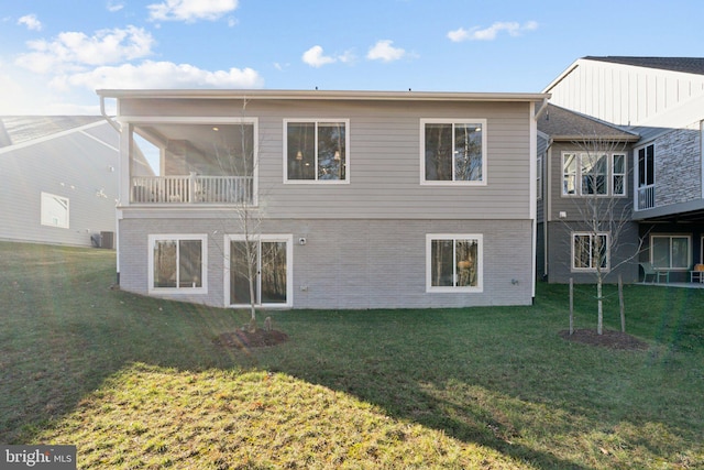 back of property with central air condition unit, a sunroom, and a yard