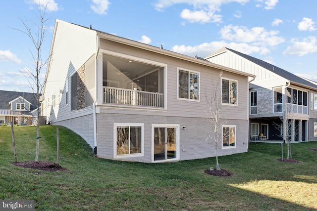 back of property featuring a lawn and a sunroom