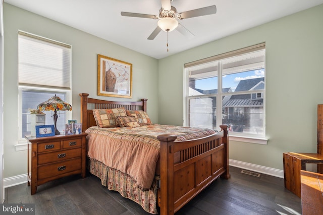 bedroom with dark hardwood / wood-style floors, ceiling fan, and multiple windows