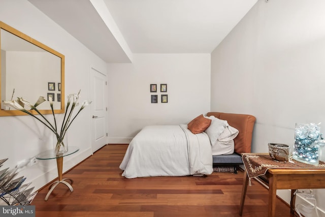 bedroom with dark hardwood / wood-style flooring