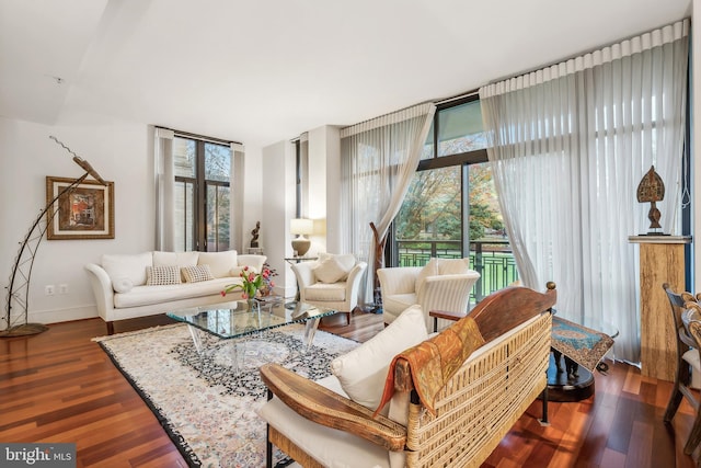 living room with dark wood-type flooring and a wall of windows