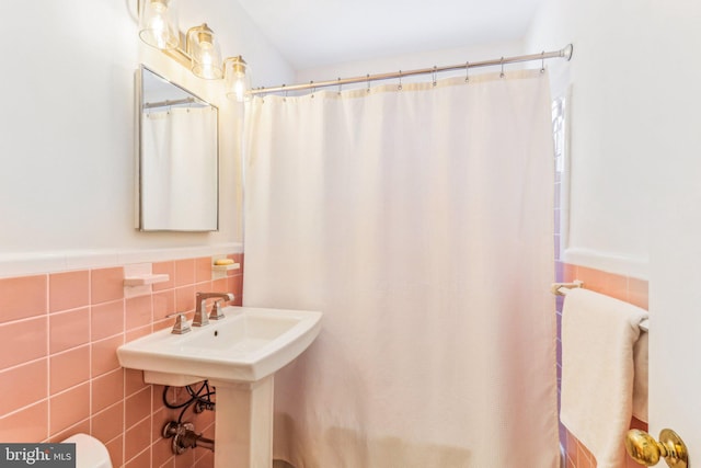 bathroom featuring walk in shower and tile walls