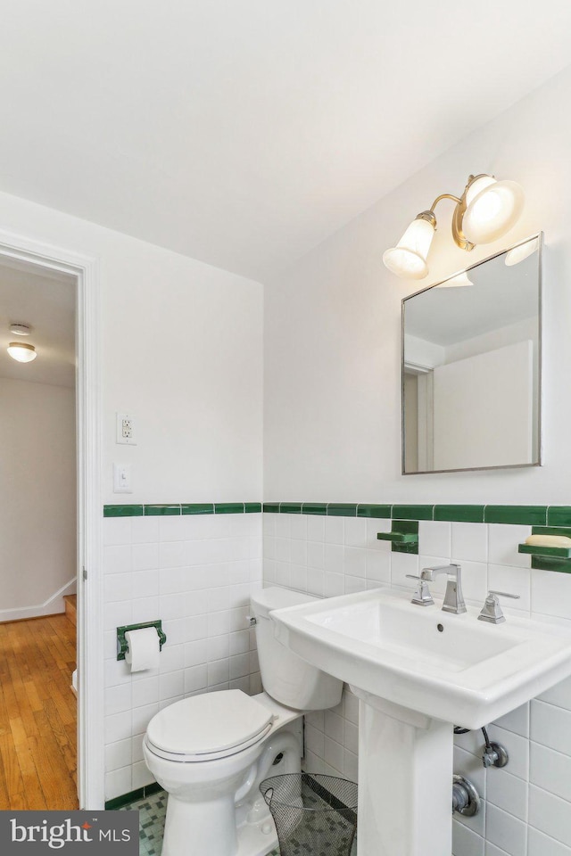 bathroom with toilet and tile walls