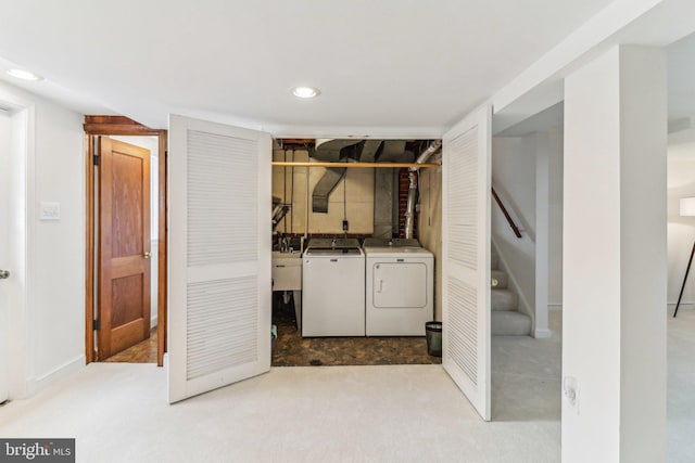 laundry room featuring light colored carpet and washer and clothes dryer