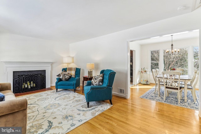 living room featuring hardwood / wood-style flooring and an inviting chandelier