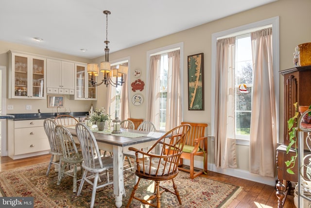 dining area with a notable chandelier, plenty of natural light, and wood-type flooring