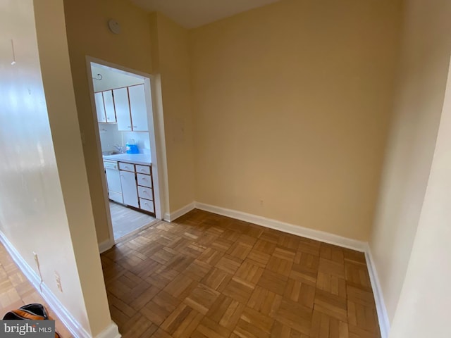 empty room with sink and light parquet floors